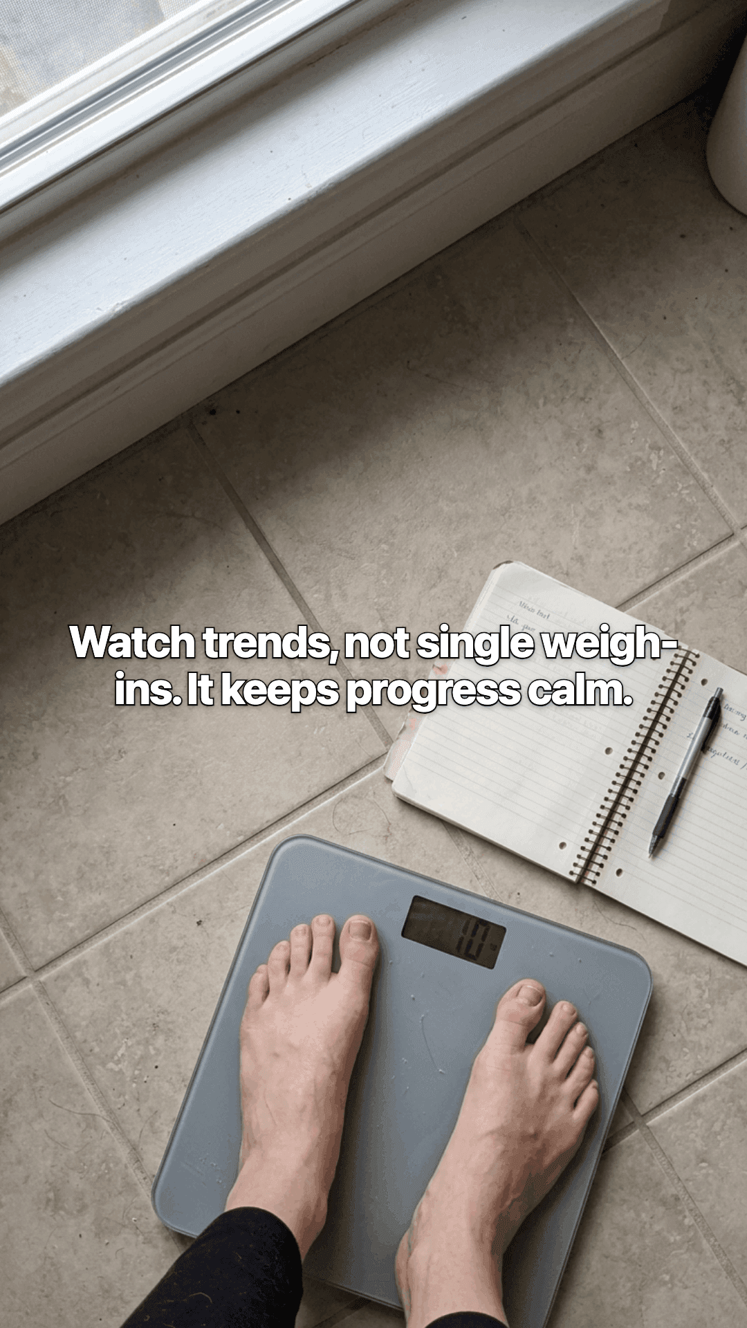 Bare feet on a bathroom scale on a tiled floor, an open notebook and pen beside it, with a line of the post across the photo.